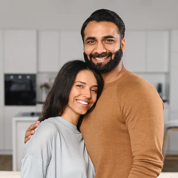 Hugging couple standing in front of kitchen 