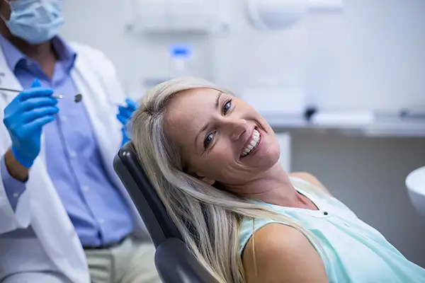 Smiling dental patient sitting in dental chair